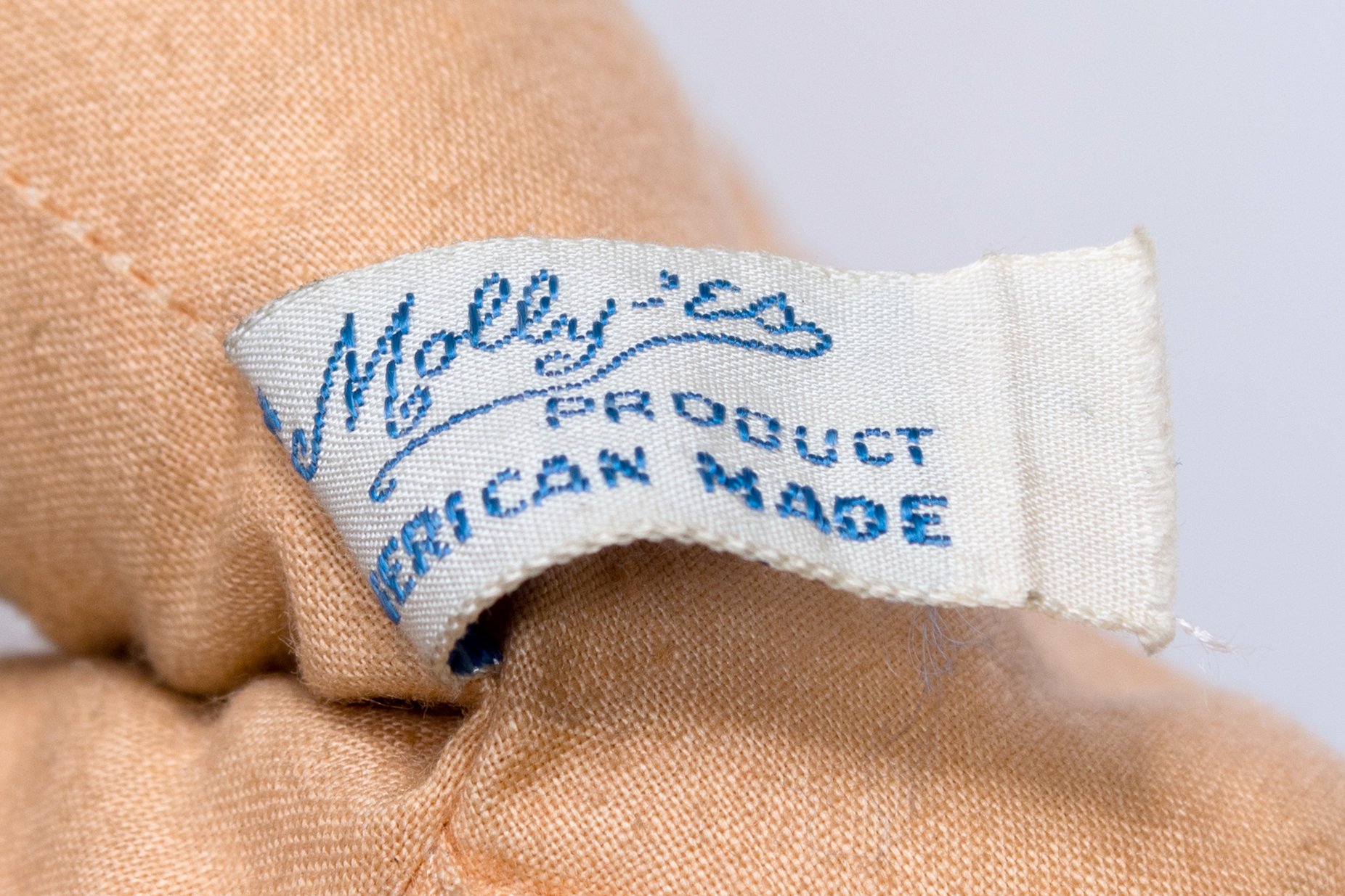 The Molly-'es product tag on the cloth doll