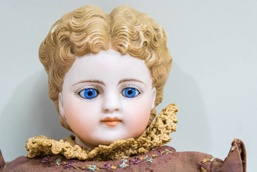 Antique Parian Doll with Blue Glass Eyes and deeply molded blonde curly hair at the Cape Fear Museum